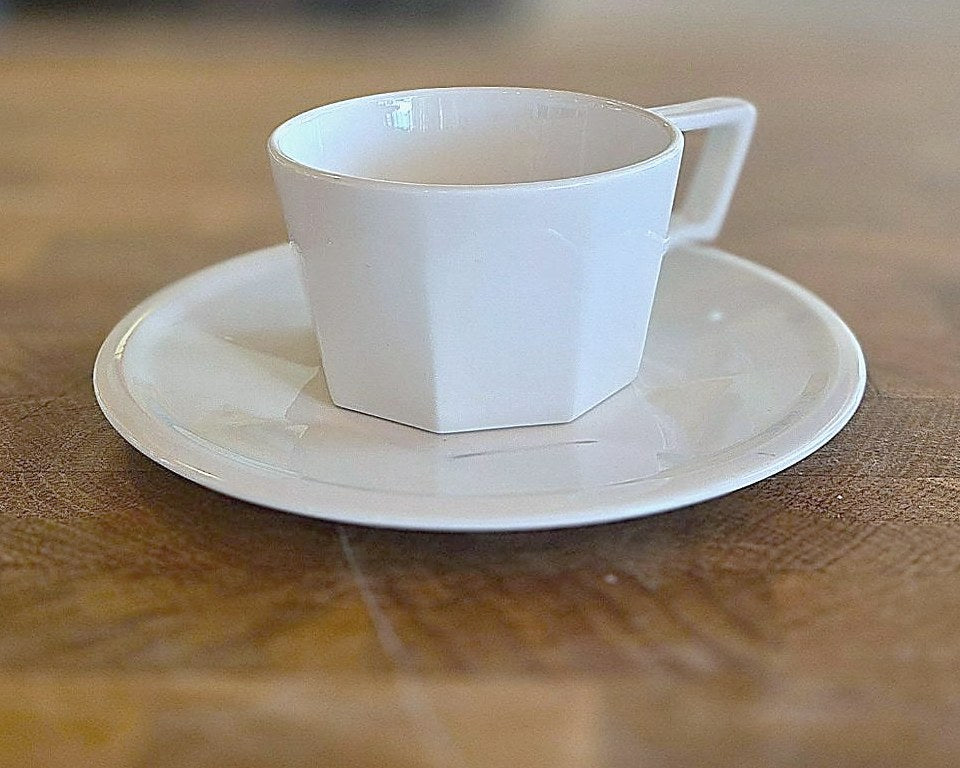 White demitasse cup and saucer on a wood table